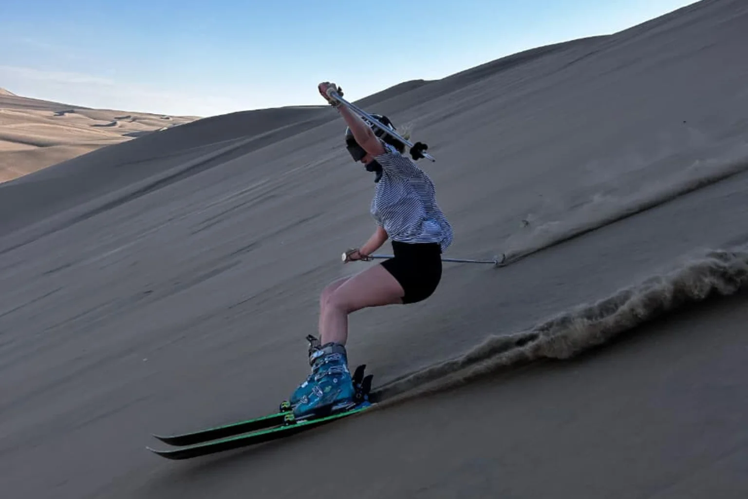 Traveler practicing the professional skiing in Huacachina sand dunes in Ica Peru - Paracas to Huacachina Bus - Wayki Bus
