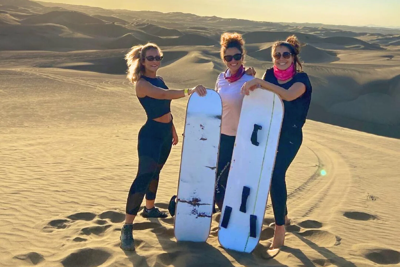 Travelers enjoying the classic sandboarding on Huacachina sand dunes in Ica Peru - Paracas to Huacachina Bus - Wayki Bus