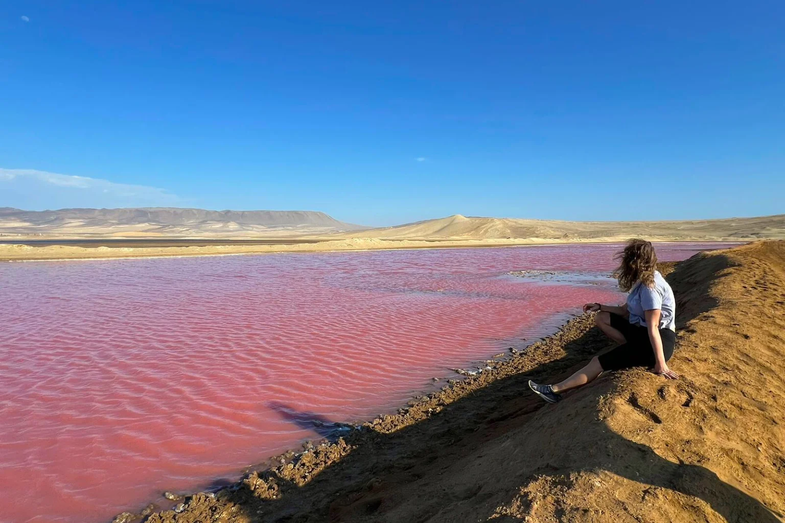 Travelers enjoying the view of the Pink Lake during the Golden Shadow Trek in Paracas - Lima to Paracas Bus - Wayki Bus