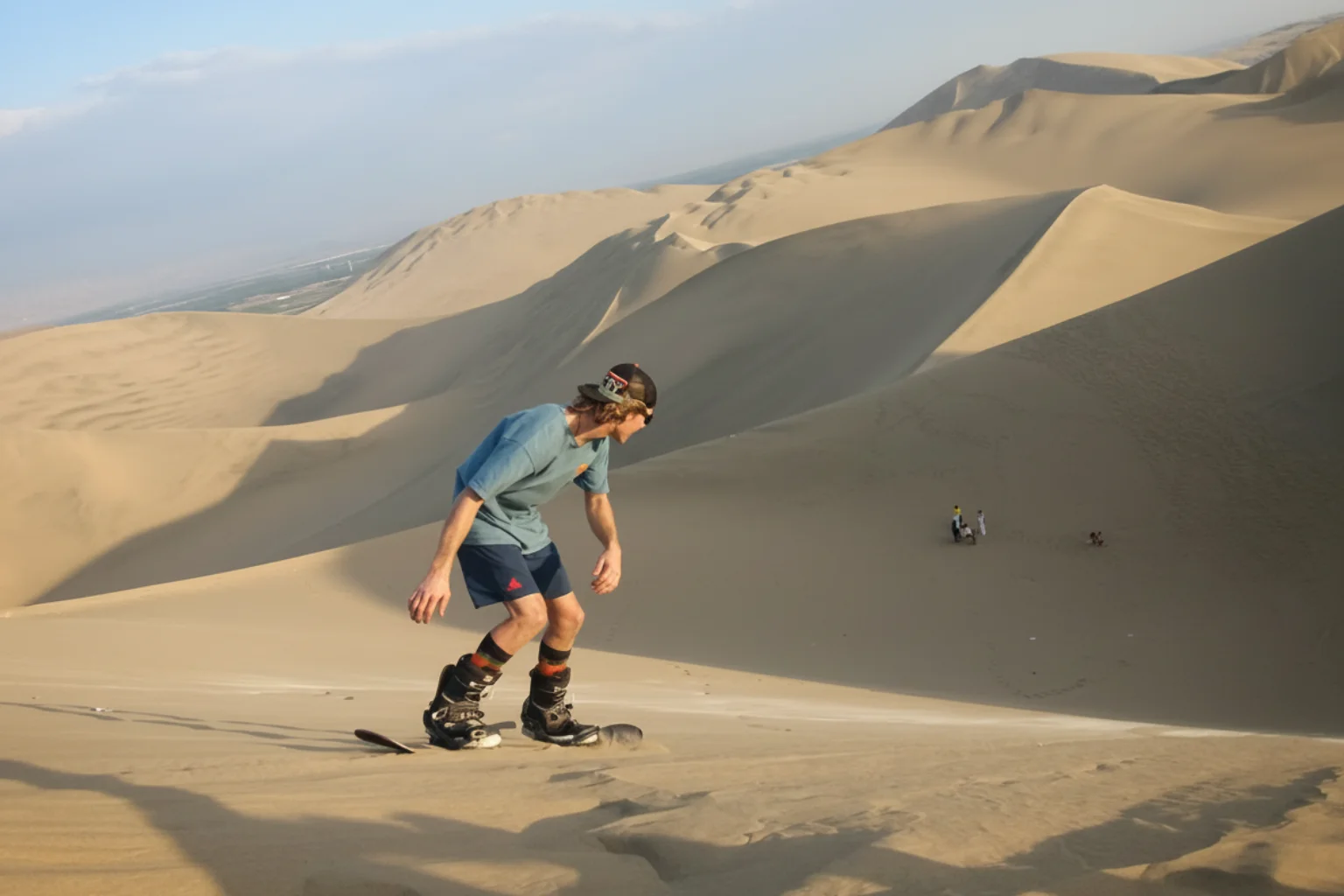 Traveler practicing the professional sandboarding on Huacachina sand dunes in Ica Peru - Lima to Huacachina Bus - Wayki Bus
